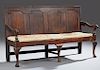 English Carved Oak Settee, 19th c., the rectangular back with three fielded panels, over loose upholstered seat cushion, flan