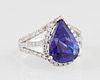 Lady's 18K White Gold Dinner Ring, with a 6.13 carats pear shaped tanzanite atop a border of small round diamonds, the pierce