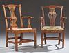 Two English Georgian Chippendale Style Carved Oak Armchairs, 19th c., one with an arched back rail over a pierced vertical sp