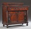 American Classical Empire Style Carved Mahogany Sideboard, 19th c., with a backsplash on a rectangular top over two frieze dr