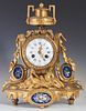 French Gilt Bronze and Porcelain Mantle Clock, 19th c., with an urn form surmount over an enamel dial drum clock, time and st
