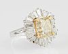 Lady's 14K White Gold Dinner Ring, with an emerald cut 4.09 carat fancy yellow diamond atop a floriform border of diamond bag