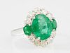 Lady's 14K White Gold Dinner Ring, with an oval 4.16 carat emerald, flanked on two sides by round emeralds, the top and botto