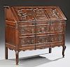 Louis XV Style Carved Oak Slant Front Secretary, 19th c., the serpentine scroll carved slant front opening to two lower drawe