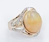 Lady's 14K Yellow Gold Dinner Ring, with an oval 6.12 carat cabochon opal, atop a tapering pierced bypass band mounted with r