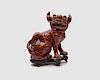 Chinese Oxblood Glazed Earthenware Figure of a Foo Lion, on a fitted wood base