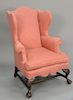 Chippendale style upholstered wing chair with carved eagle heads and ball and claw feet. ht. 46 1/2in.