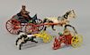 Two cast iron horse drawn toys including single horse with wagon and rider and a small triple horse with fire pumper wagon. lg. 5 1/...