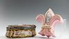Two French Gilt Decorated Porcelain Dresser Boxes, late 19th c., the pink example of fleur-de-lis form, painted with a lady with flowers in a landscap