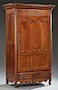 French Louis XV Style Inlaid Carved Cherry Armoire, c. 1800, the stepped canted corner ogee crown over a large single door with double shaped panels, 
