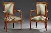 Pair of French Directoire Style Carved Cherry Fauteuils, 20th c., the scrolled carved crest rail above upholstered backs flanked by upholstered arms a