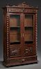 French Henri II Style Carved Oak Bookcase, c. 1880, the arched crest over a stepped crown above setback double doors with glazed upper panels, over re