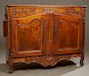 French Provincial Carved Walnut Bultoir Sideboard, 18th c., with a rounded corner stepped top with lifting lid over interior storage above double arch