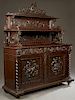 Highly Carved Oak Jacobean Style Sideboard, c. 1890, attribited to R. J. Horner, New York, the pierce carved shield crest over two graduated shelves o