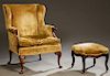 Queen Anne Style Carved Mahogany Wing Chair, early 20th c., the upholstered back over rolled scrolled arms, and a removable cushion on Queen Anne legs