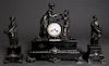 Three Piece French Patinated Spelter and Black Marble Figural Clock Set, c. 1880, the time and strike drum clock by Vincente & Cie. flanked by a figur