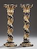 Pair of Aesthetic Style Gilt and Ebonized Pedestals, 20th c., the circular top above a gilt capital, on a twist column with a relief leaf garland, to 