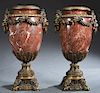 Pair of Bronze Ormolu Mounted Red Marble Urns, 20th c., the bronze rim over a ring mounted with lions head ring handles joined by floral garlands, on 