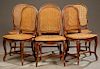 Set of Six French Louis XV Style Carved Walnut Caned Dining Chairs, early 20th c., the shaped medallion caned backs and bowed caned seats, on cabriole