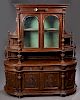Large French Henri II Style Carved Walnut Sideboard, c. 1880, the stepped crown over setback double arched beveled glass doors flanked by turned colum