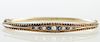 English 15K Yellow Gold Hinged Bangle Bracelet, Birmingham, c. 1900, the tapered top with six graduated round sapphires, separated by five graduated r