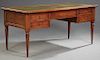 French Louis XVI Style Carved Cherry Desk, 20th c., the stepped top with an inset gilt tooled leather writing surface over a centered drawer flanked b