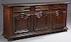 French Louis XVI Style Carved Oak Sideboard, 20th c., the thick rounded edge top over three frieze drawers, separated by applied reeded pilasters abov