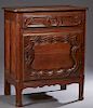 French Provincial Carved Oak Confiturier, 19th c., the stepped rounded edge and corner top over a frieze drawer and a fielded panel cupboard door with