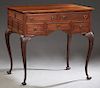 English Carved Mahogany Lady's Writing Desk, c. 1900, the rectangular top over two frieze drawers and three lower drawers, on graceful cabriole legs w