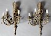 Pair of Louis XVI Style Brass Three Light Wall Sconces, 20th c., with a torch and quiver back plate, issuing three scrolled arms with relief bobeches 