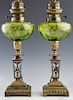 Diminutive Pair of French Champleví© and Art Glass Oil Lamps, 19th c., the green glass font with gilt decoration, on a rectangular champleve column to