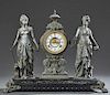 Ansonia Cast Iron and Patinated Spelter Open Escapement Double Figural Mantle Clock, c. 1880, the urn surmounted drum clock, time and strike, with an 