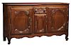 French Provincial Carved Oak Louis XV Style Sideboard, 20th c., the stepped rounded edge and corner top over a central frieze drawer above a cupboard 