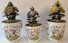 Three piece lot including a pair of porcelain urns with porcelain sprouting flowers having faces on sides and another near matching ...