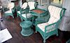 Eight pieces of antique Bar Harbor wicker to include two wing chairs, bookcase, one tall round top table, one low stool, two armchai...
