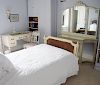 Bedroom contents including caned twin bed, hall table with mirror, vanity, chair, bookcase, table, lamp, and three pictures. 
bed: h...