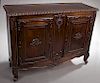 French Carved Walnut Louis XV Style Sideboard, late 19th c., the carved edge cookie corner top over two fielded panel cupboard doors with applied shel
