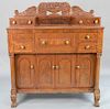 Federal mahogany sideboard having large carved compote of fruit with center drop front desk drawer, circa 1840. 
height 65 in., widt...