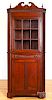 Red stained two-part corner cupboard, 19th c.
