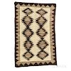 Navajo Regional Rug, c. 1920s, woven with natural and synthetic spun wool, the serrated diamond pattern with dark border on a natural g