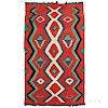 Navajo Transitional Rug, c. 1900, homespun wool, multicolored "eye dazzler" pattern on a red background, with fringe either end, (stain