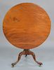 Mahogany tip table on urn turned shaft, set on tripod base. height with wheels 28 1/4 in., diameter 34 in.