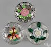Three antique glass paperweights, to include two fruit and floral examples with latticino grounds