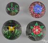 Four floral paperweights of varying sizes, to include an iris, anemones, and a millefiori