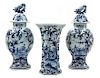 A Delft Pottery Three-Piece Garniture Height of covered vase 14 inches.