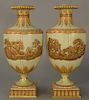 Pair of Wedgwood gilt decorated Victoria ware vases/urns, 
pale green with gold jeweled ground, central gilt relief chariot with put...
