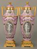 Pair of Sevres pate-sur-pate porcelain urns with covers, 
having gilt bronze finial on cover over gilt bronze mounted handles and ce...