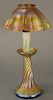 Tiffany art glass lamp, 
scallop edge shade, iridescent gold with pink highlights, candle style base with twisted bulbous base and i...