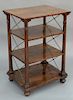 Rosewood etagere with rectangular top, 
over three shelves held up by turned columns and supported by brass X's, set on ball feet. 
...