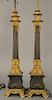 Pair of bronze and gilt bronze lamps made from candlesticks, 
each with four gilt northwind faces and triple socket tops, set on scr...